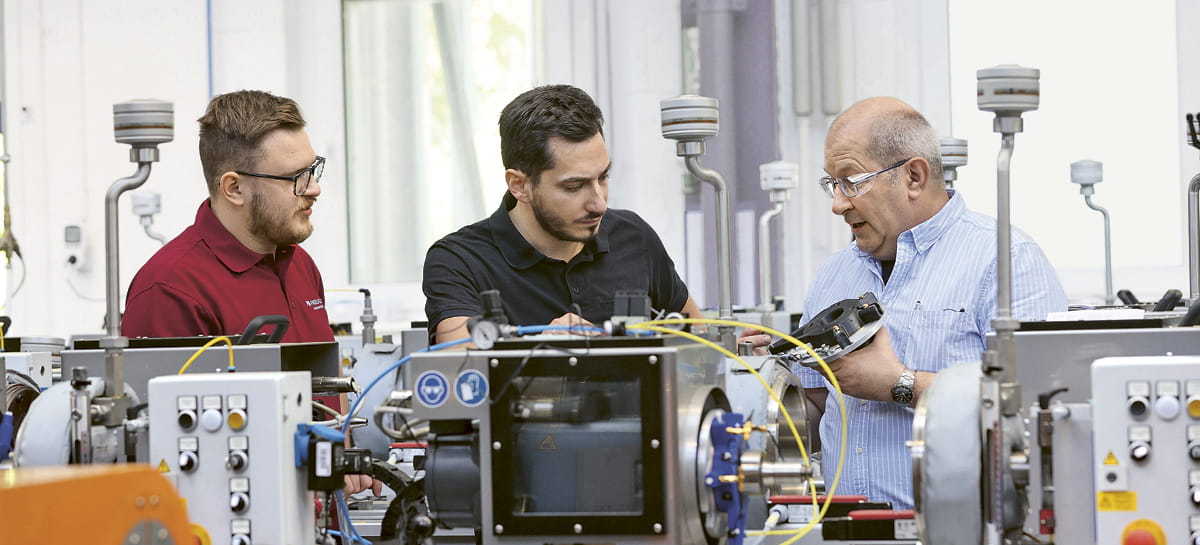 Robert Leins, Manager of the Weinheim test facility in Germany, inspects a new test stand along with two colleagues. 