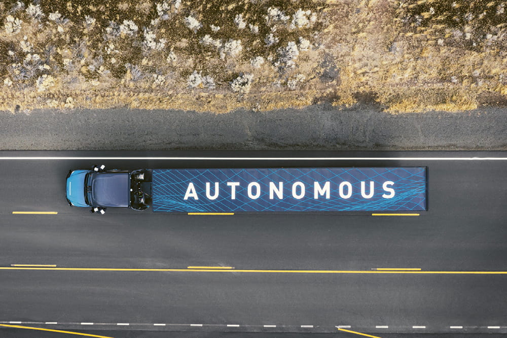 A truck labeled Autonomous is driving on a road.